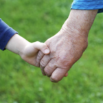 Close up of hands, boy holding hands with older woman